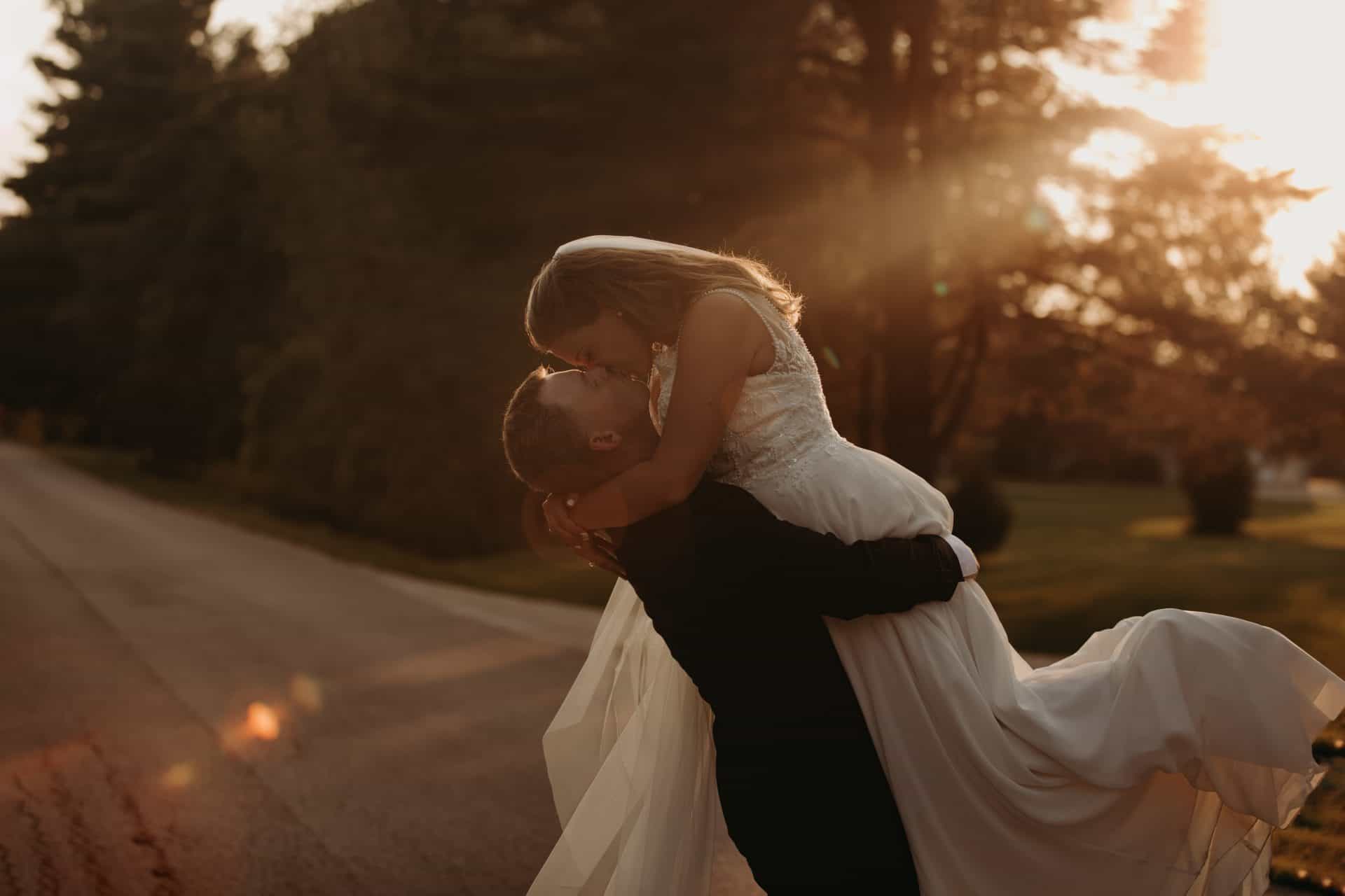 sunset wedding day bride and groom kissing