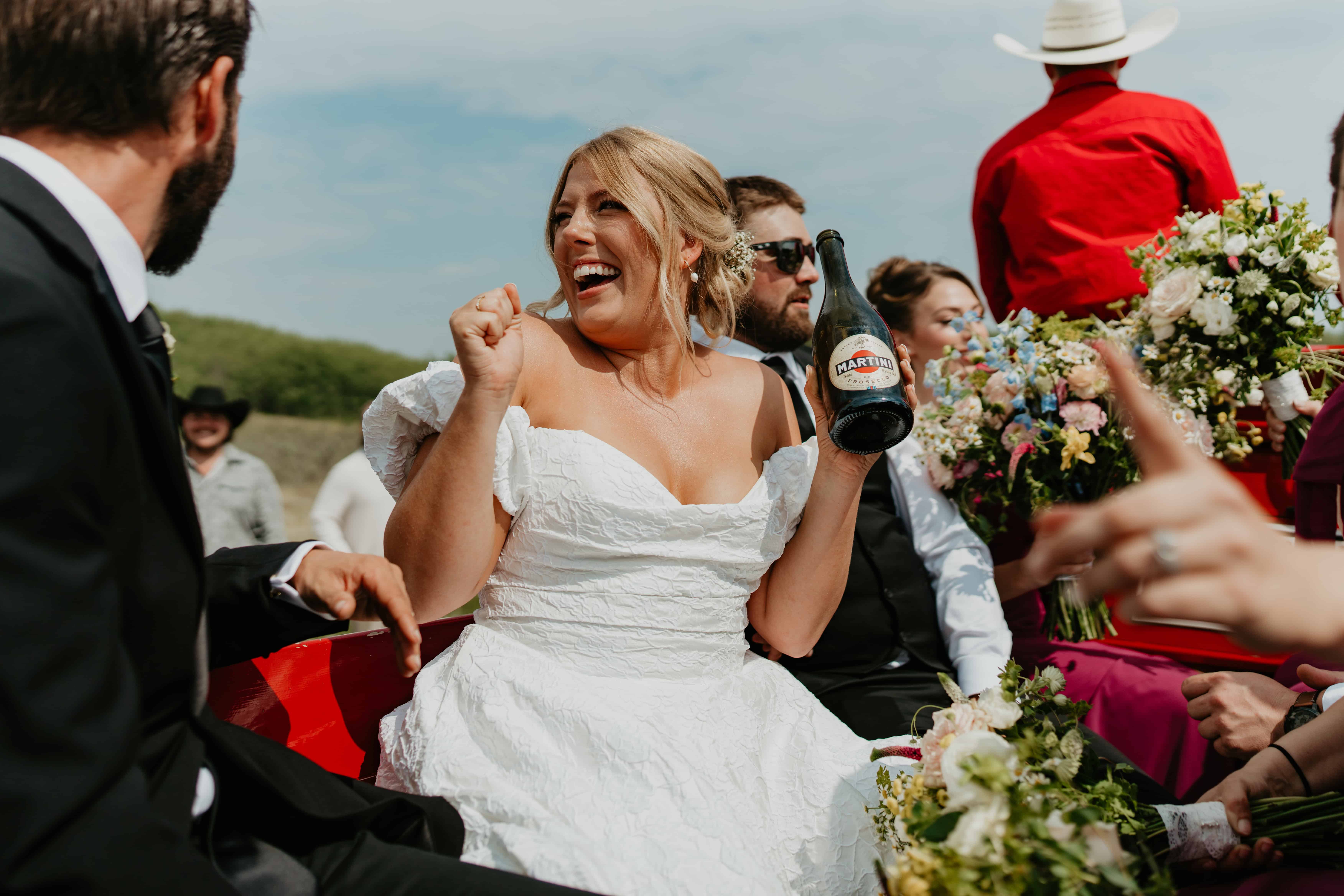 bride celebrating with a champagne bottle. documentary candid photo